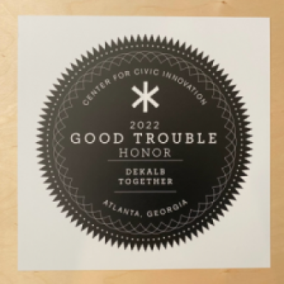 Black circular award emblem with "2022 Good Trouble Honor" and "Center for Civic Innovation." Text includes "Dekalb Together" and "Atlanta, Georgia."