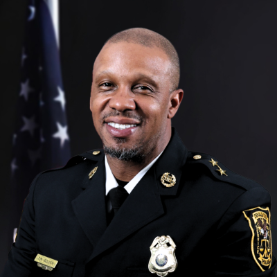 Uniformed public safety official smiling for a professional portrait