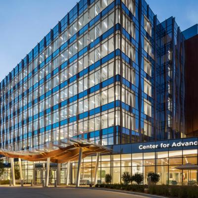 Front entrance image of Children's Healthcare of Atlanta light up inside that has blue and green on the outside of it which was taken just before dusk dark.
