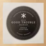 Black circular award emblem with "2022 Good Trouble Honor" and "Center for Civic Innovation." Text includes "Dekalb Together" and "Atlanta, Georgia."