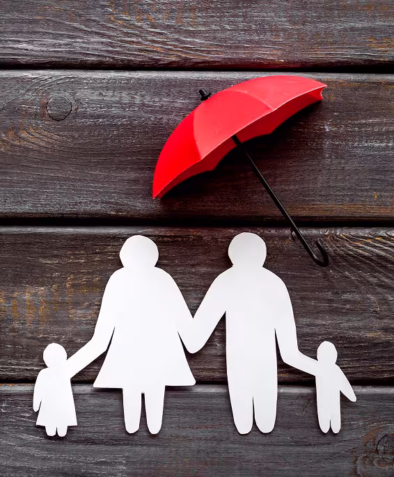 White paper cut out of a family, parents and two kids, with a red umbrella over them.