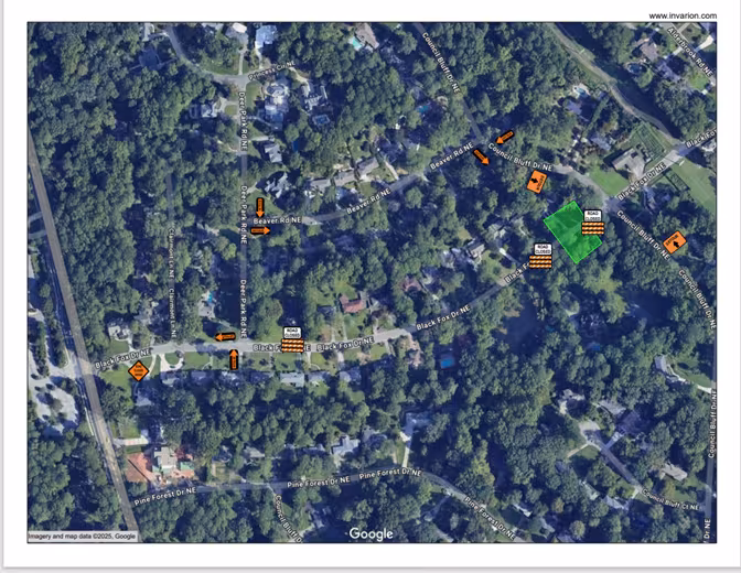 Aerial map showing a residential neighborhood with tree coverage. Several orange construction signs and roadwork symbols are scattered throughout.