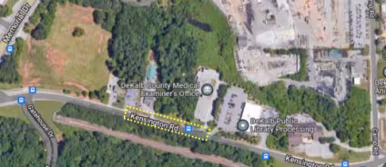 Aerial map view showing a green area with buildings labeled DeKalb Medical Examiner's Office and DeKalb Public Library Processing, along Kensington Rd.