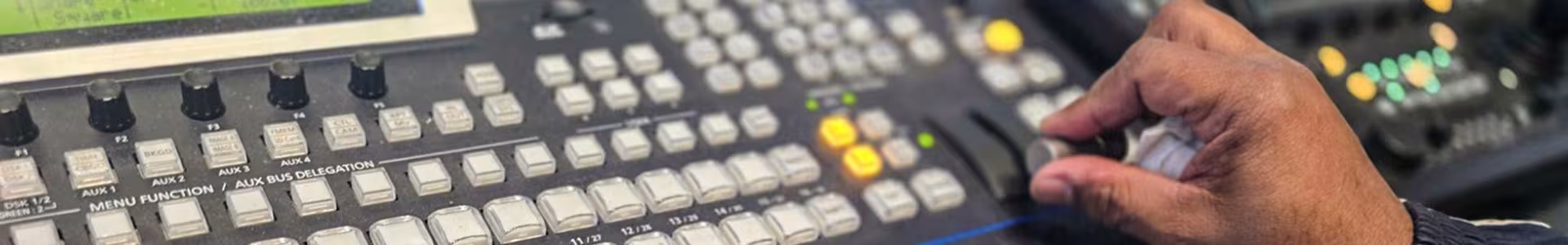 Person operating a grey switcher during a DCTV news production.